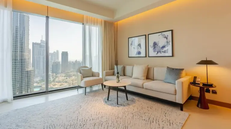 a living room with a couch and a large window at The Address Residences Dubai Opera - Luxury 3BR Stay with Stunning Burj Khalifa & Fountain Views in Dubai