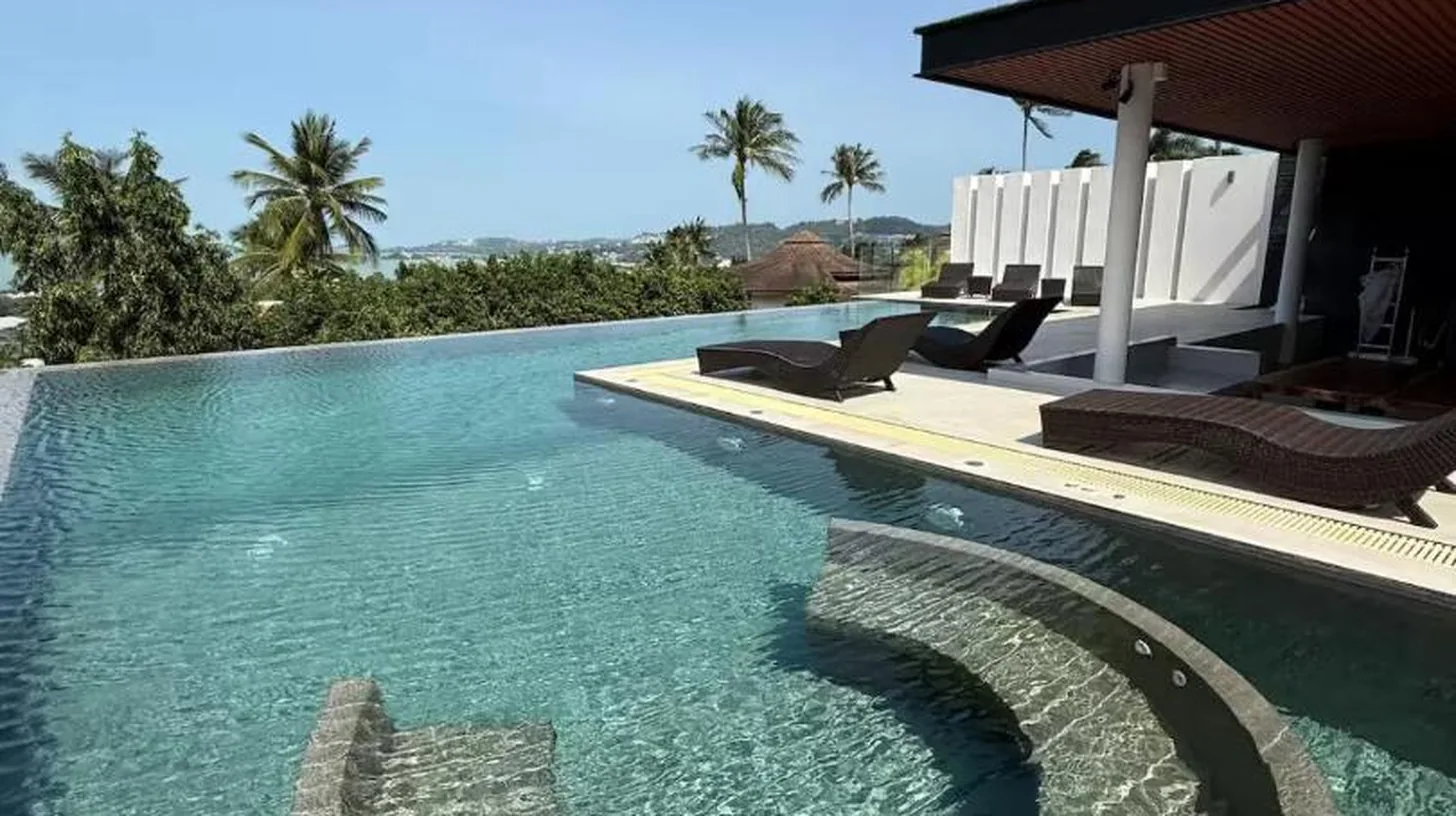 a swimming pool with a path in the water at The Akbar Villa in Bang Rak Beach