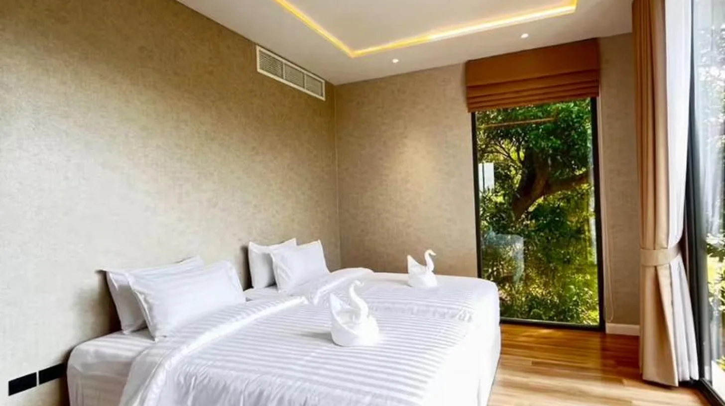 a bedroom with a large white bed with white pillows at The Akbar Villa in Bang Rak Beach