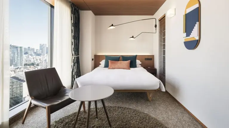 a bedroom with a bed and a table and a chair at THE AOYAMA GRAND HOTEL in Tokyo