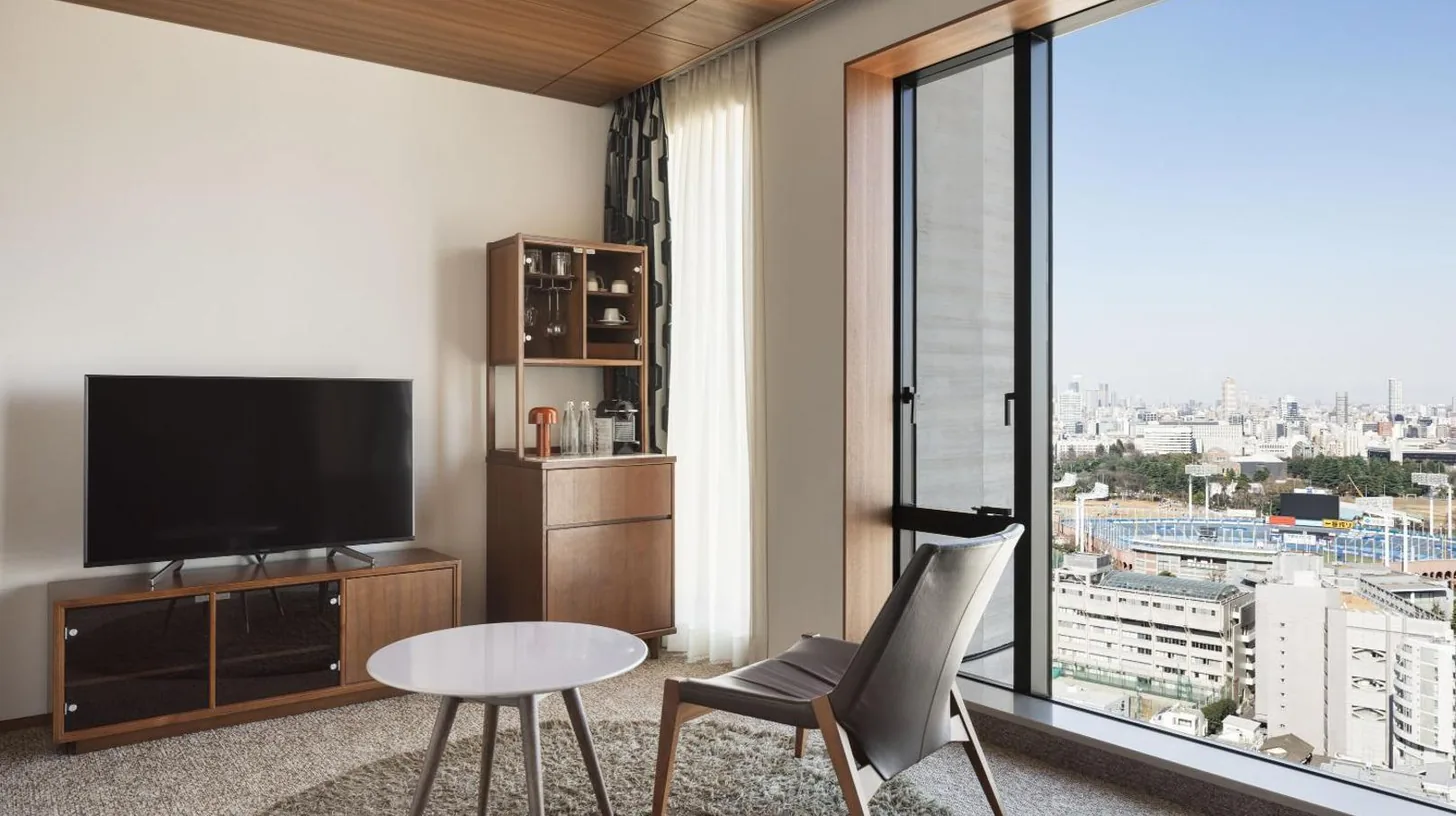 a living room with a television and a table at THE AOYAMA GRAND HOTEL in Tokyo