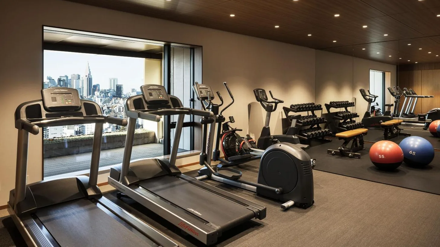 a gym with cardio equipment and a large window at THE AOYAMA GRAND HOTEL in Tokyo