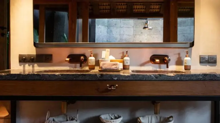ein Badezimmer mit Waschbecken und Spiegel im The Asa Maia - Bespoke Wellness Resort in Uluwatu