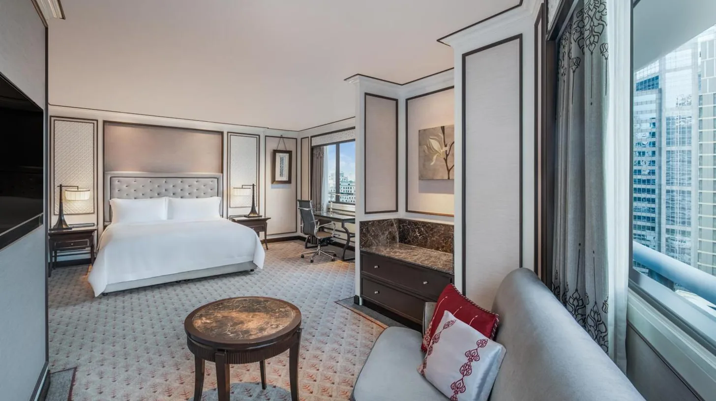 a bedroom with a large white bed and a desk at The Athenee Hotel