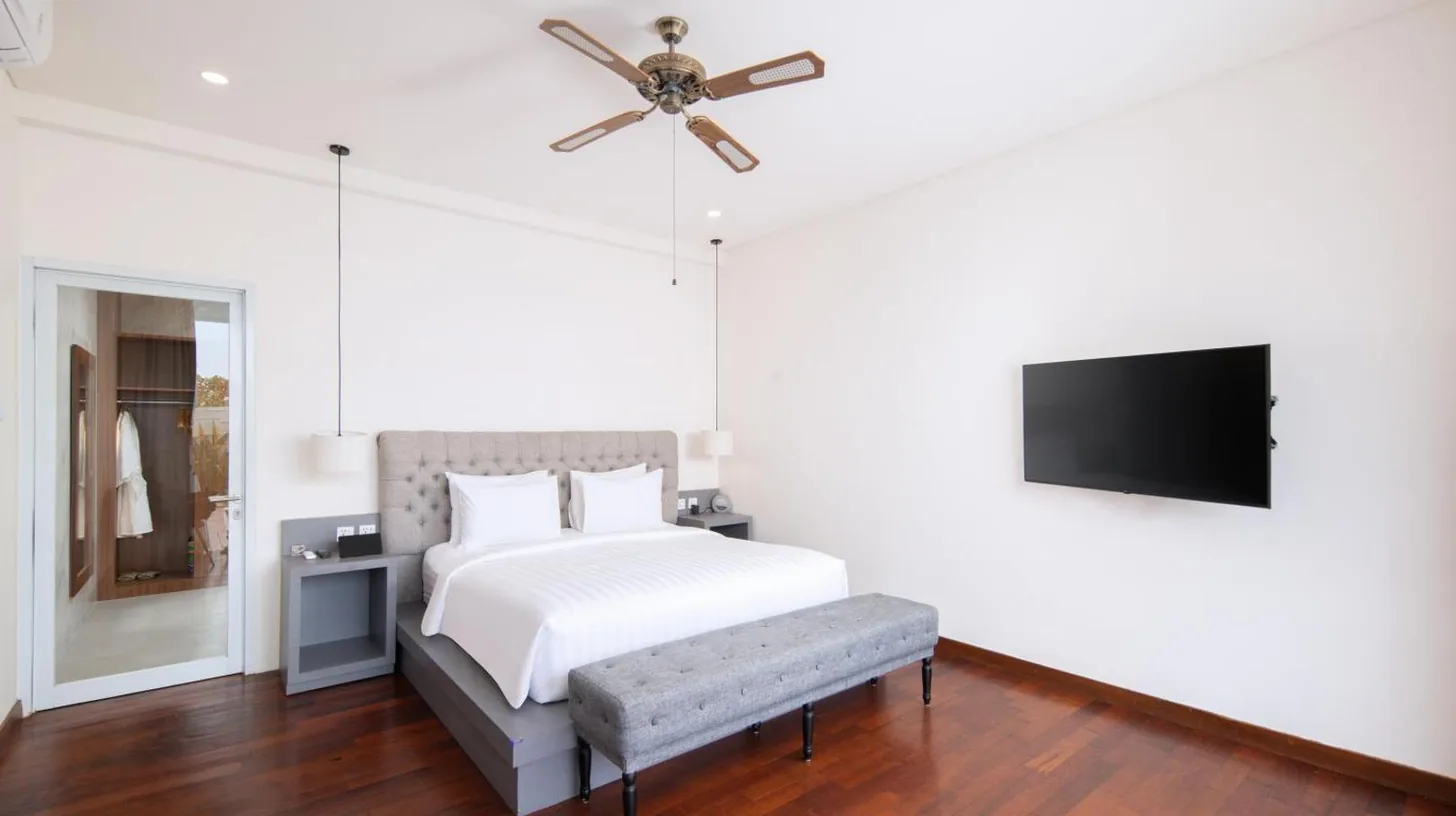 a bedroom with a bed and a ceiling fan at The Daha Luxury Villas in Seminyak