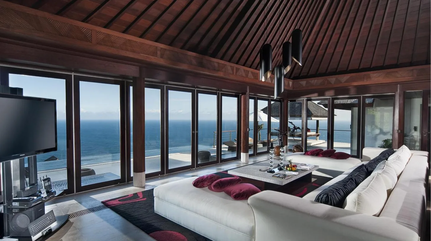 a living room with a white couch and a view of the ocean at The Edge Bali in Uluwatu