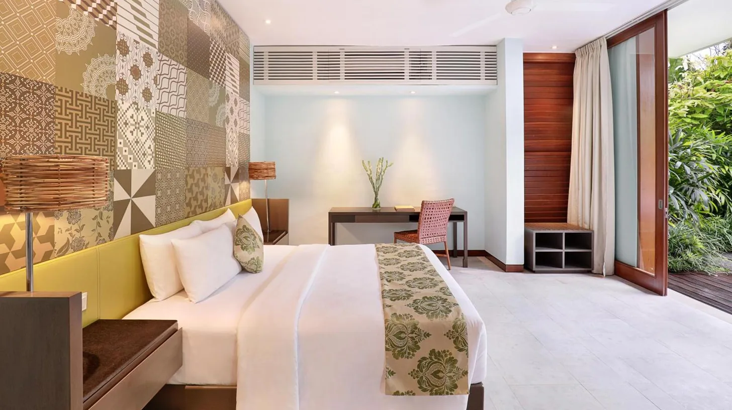 ein Schlafzimmer mit einem Bett und einem Schreibtisch im The Elysian Boutique Villa Hotel in Seminyak