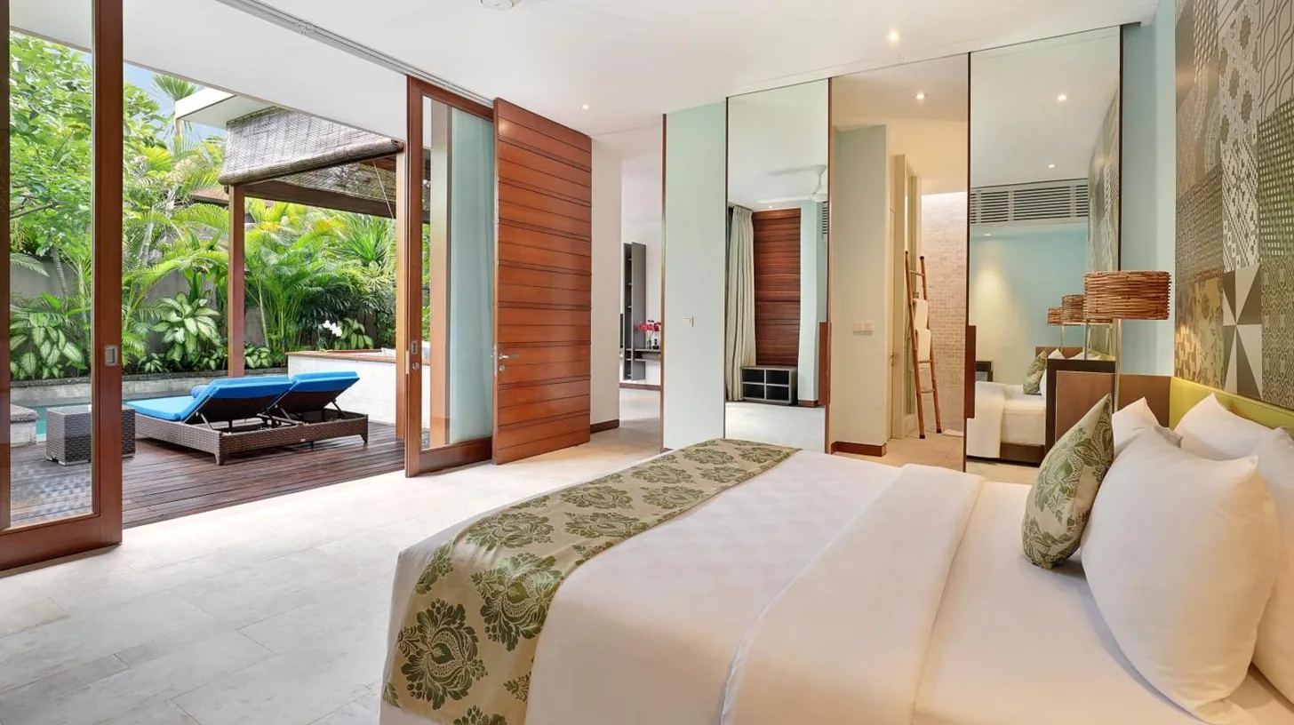 ein Schlafzimmer mit einem großen Bett und einer Terrasse im The Elysian Boutique Villa Hotel in Seminyak