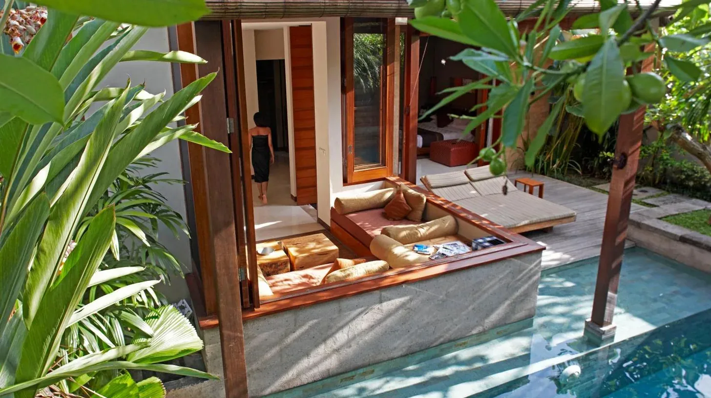 eine Villa mit einem Schwimmbecken und einem Haus im The Elysian Boutique Villa Hotel in Seminyak