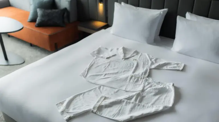 a white robe on a bed in a room at The Gate Hotel Osaka by Hulic in Osaka
