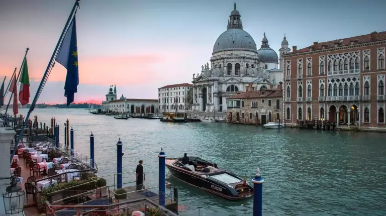 a boat in the water in front of a building at The Gritti Palace