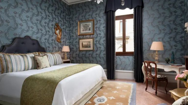 a bedroom with a bed and a couch and a chair at The Gritti Palace