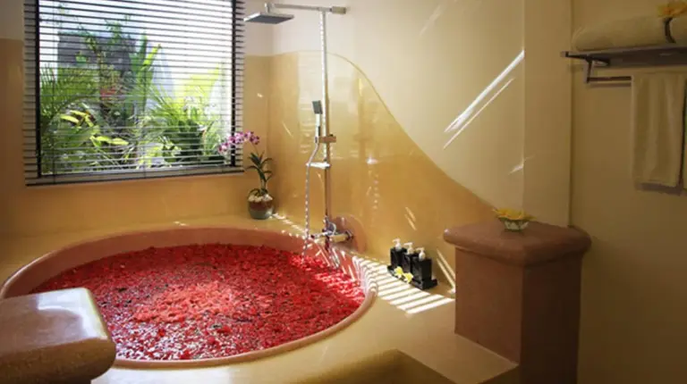 a bathroom with a large red bath tub with a window at The Haere Seminyak - By Astadala in Seminyak