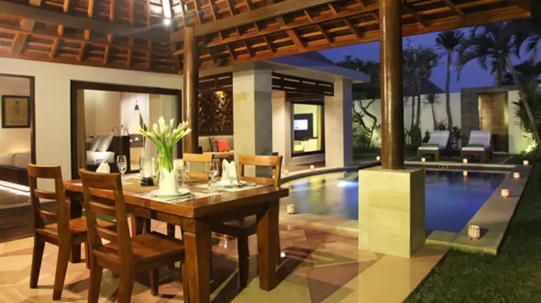 a dining room with a table and a swimming pool at The Haere Seminyak - By Astadala in Seminyak