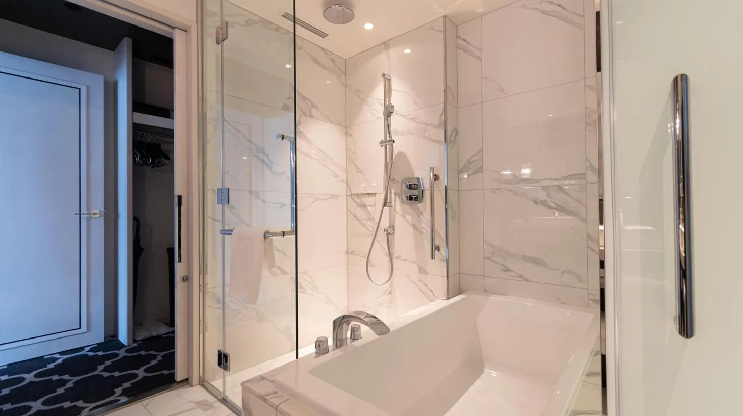 a white bathroom with a tub and a shower at The Kahala Hotel & Resort Yokohama in Yokohama