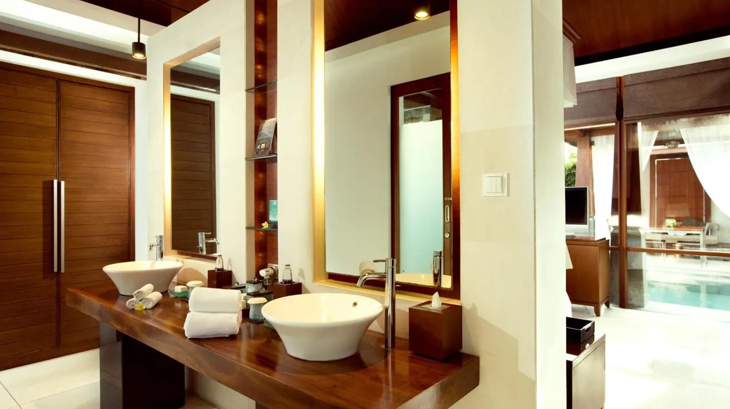 a bathroom with two sinks on a wooden counter at The Kayana in Seminyak