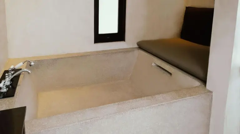 a bath tub in a small room with a window at The Lamai Samui in Lamai