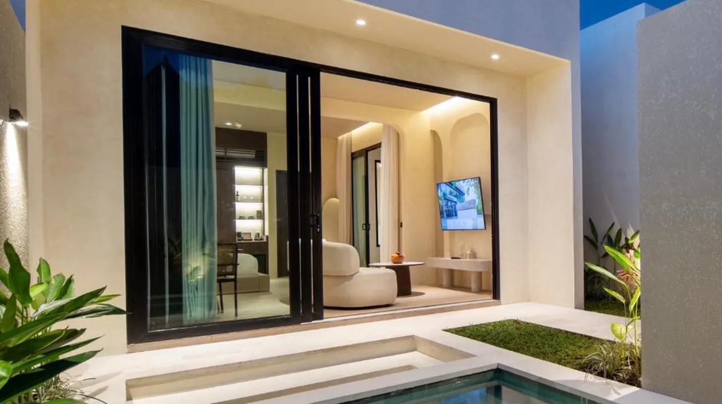 a swimming pool in front of a house at The Lario Collection - A Wellness Resort in Seminyak