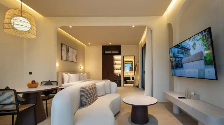 a bedroom with a white bed and a table at The Lario Collection - A Wellness Resort in Seminyak