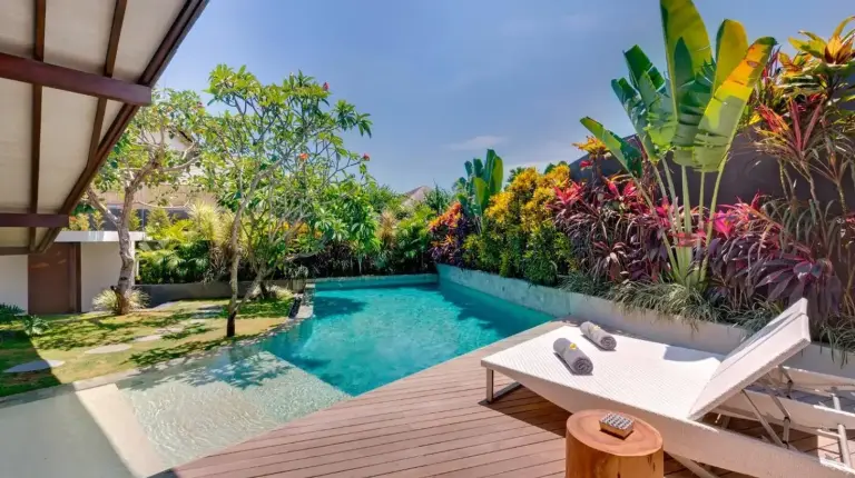 a swimming pool next to a wooden deck with a tub at The Layar - Designer Villas and Spa in Seminyak
