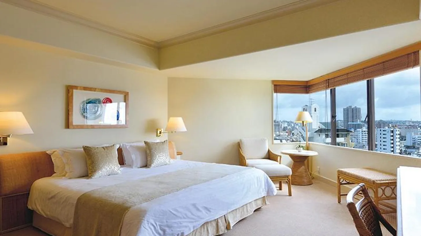 a bedroom with a large bed and a large window at The Naha Terrace in Naha