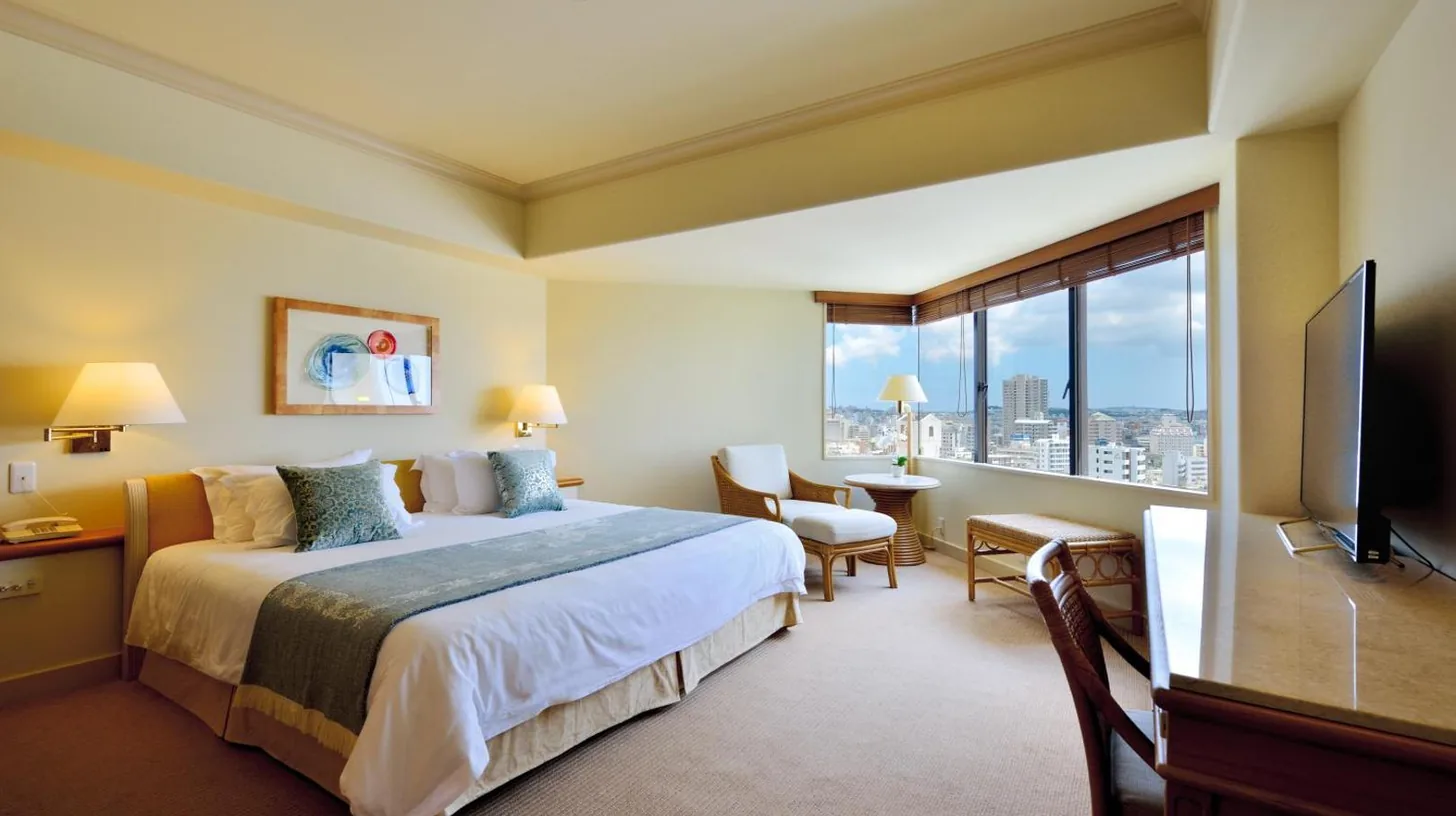 a bedroom with a bed and a desk and a television at The Naha Terrace in Naha