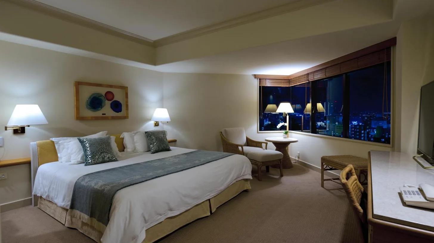 a bedroom with a large white bed with two pillows at The Naha Terrace in Naha