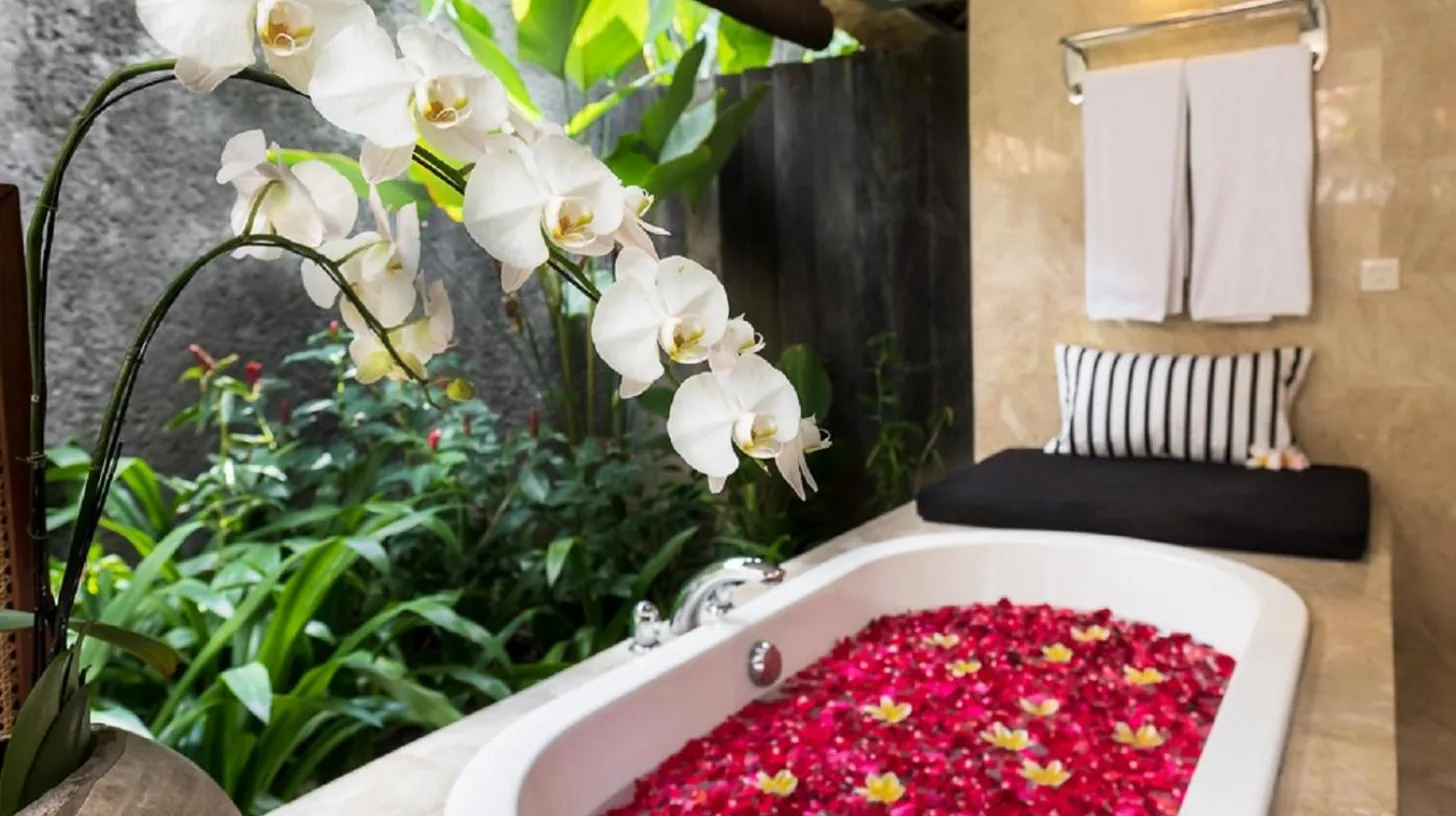 a bathroom with a bath tub filled with red flowers at The One Boutique Villa & Spa Seminyak in Seminyak