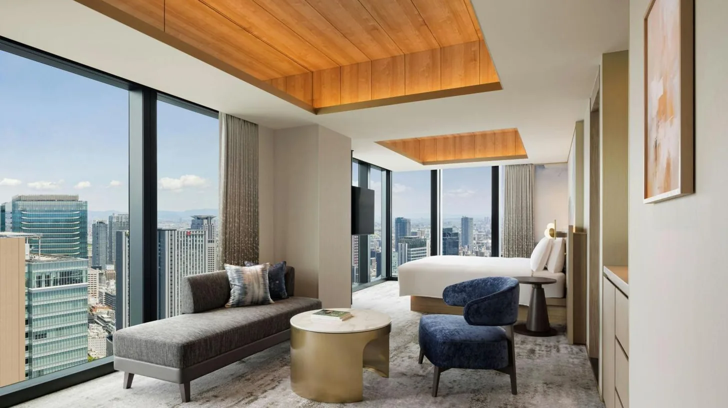 a living room with a couch and a tv at THE OSAKA STATION HOTEL