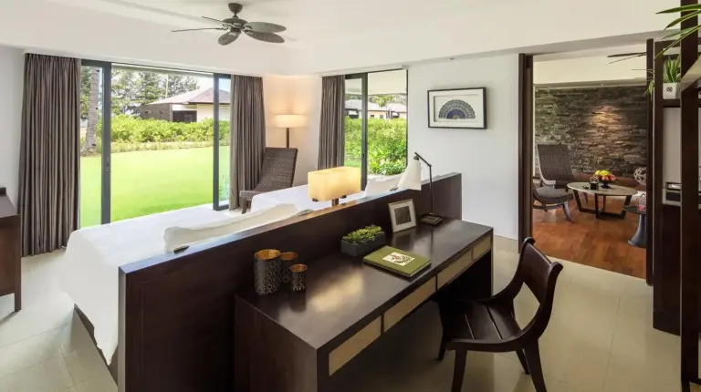 a bedroom with a bed and a desk in a room at The Residence Bintan in Kawal
