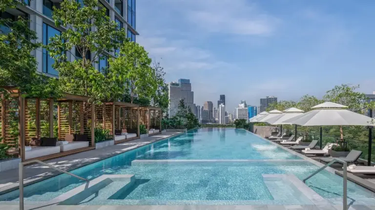 a swimming pool with chairs and umbrellas next to a building at The Ritz-Carlton