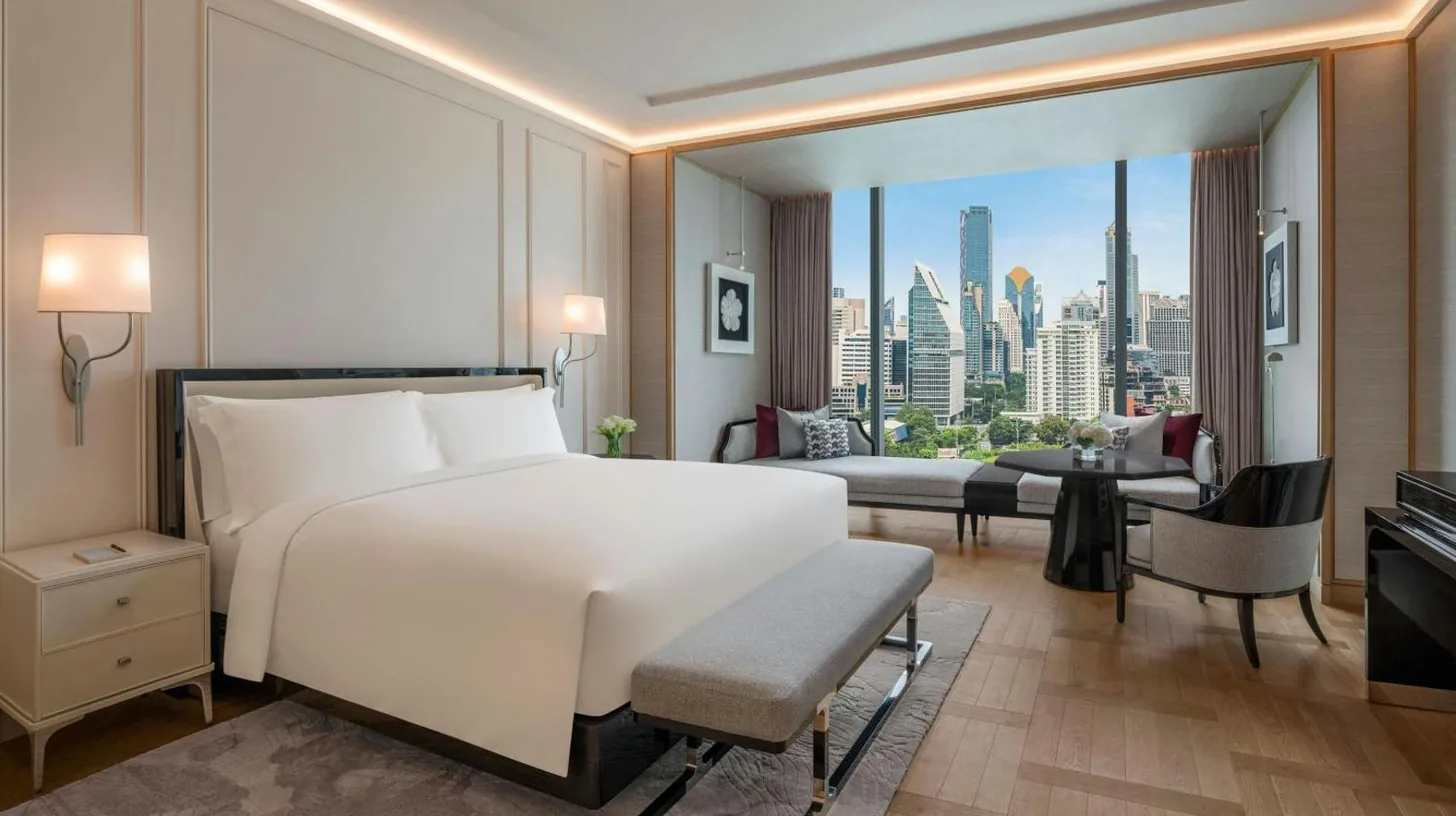 a bedroom with a large white bed and a couch at The Ritz-Carlton