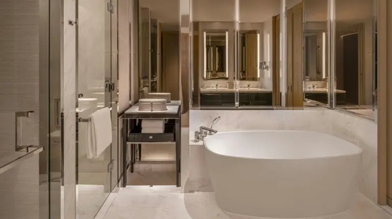 a bedroom with a white bed and a view of a city at The Ritz-Carlton
