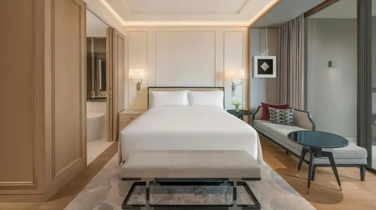 a bedroom with a large bed and a living room at The Ritz-Carlton