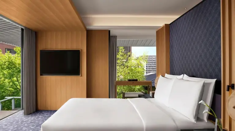 a bedroom with a large white bed and a flat screen tv at The Ritz-Carlton Kyoto in Kyoto