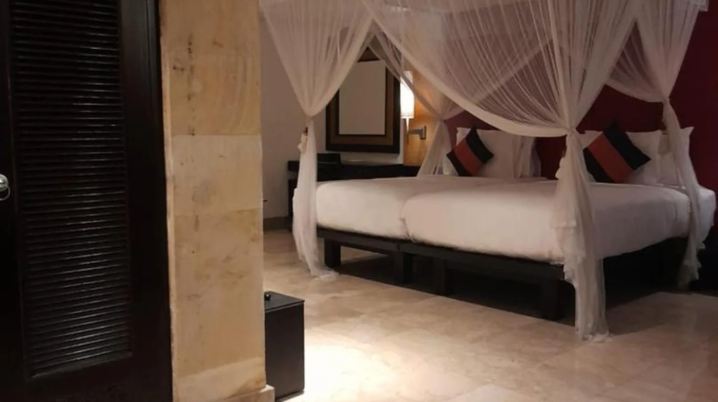 a bedroom with two white beds with mosquito nets at The Royal Beach Seminyak Bali in Seminyak