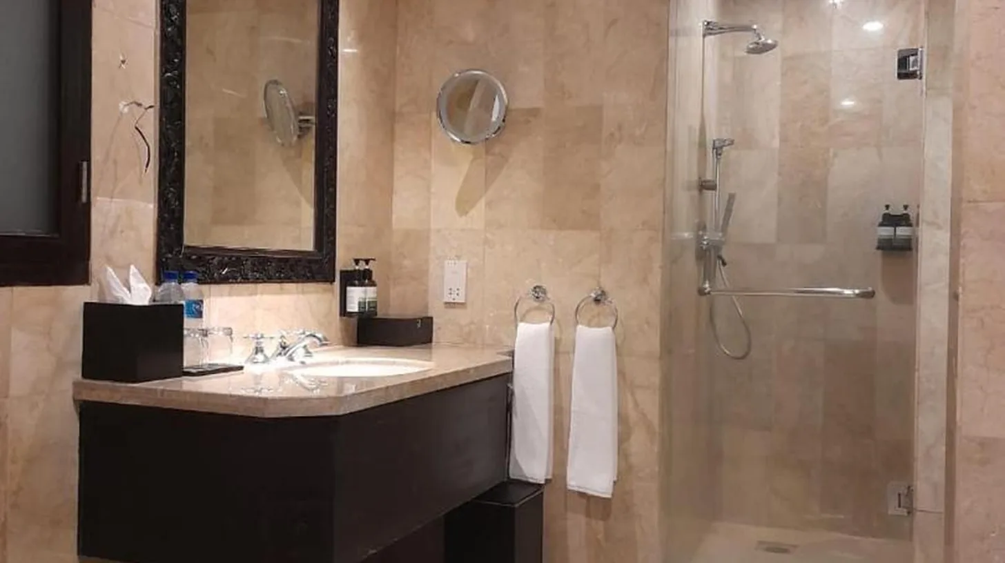 a bathroom with a large sink and a shower at The Royal Beach Seminyak Bali in Seminyak