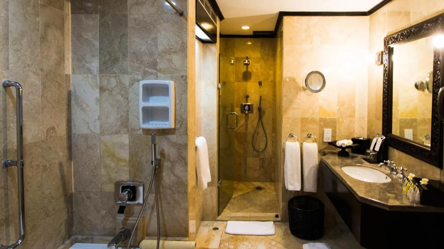 a bathroom with a shower and a tub and a sink at The Royal Beach Seminyak Bali in Seminyak