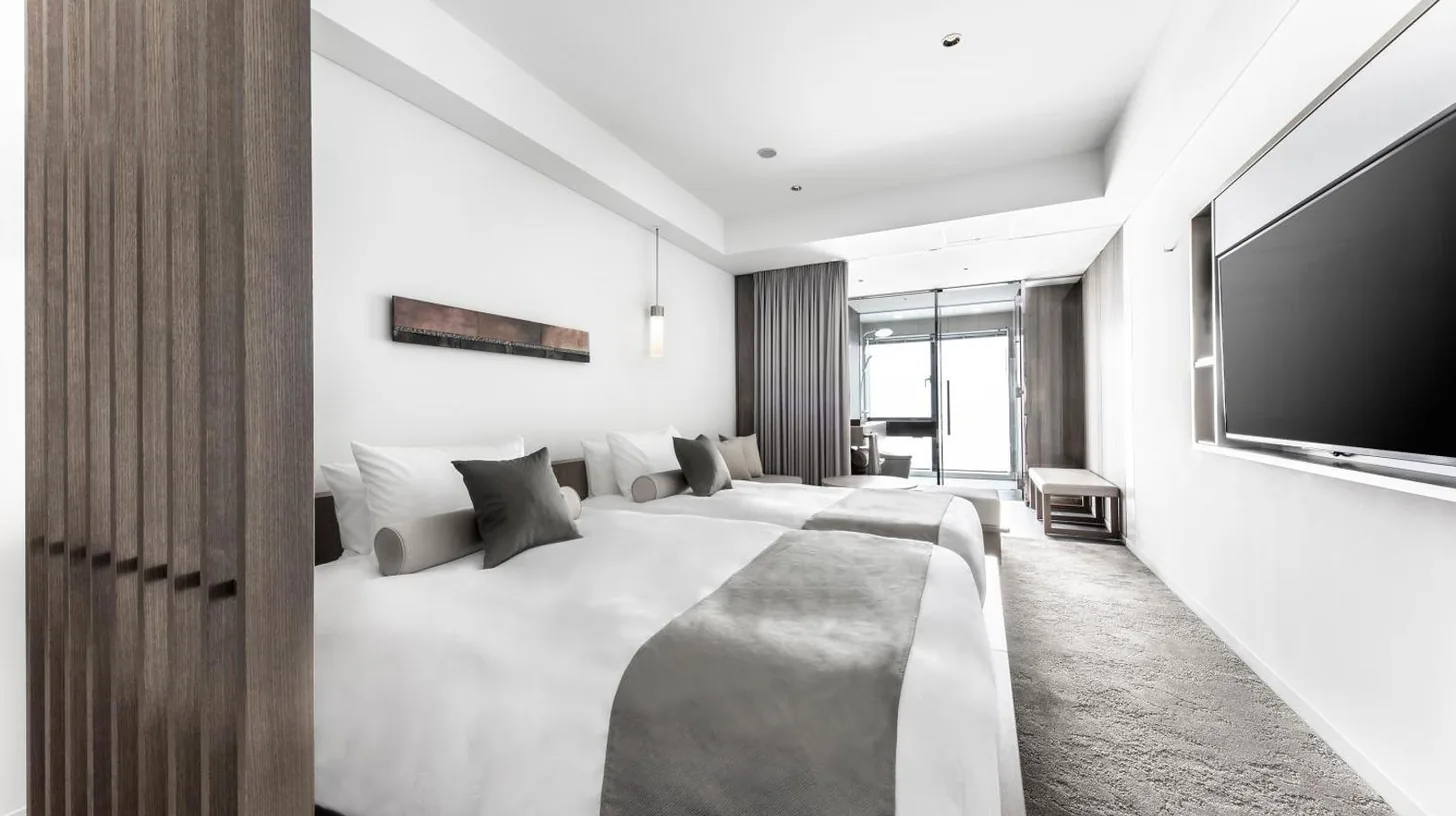 a bedroom with a large bed and a flat screen tv at The Royal Park Hotel Iconic Kyoto in Kyoto