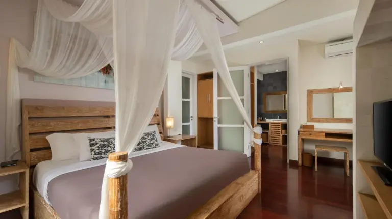 a bedroom with a canopy bed and a desk at The Seiryu Boutique Bali Villas in Seminyak