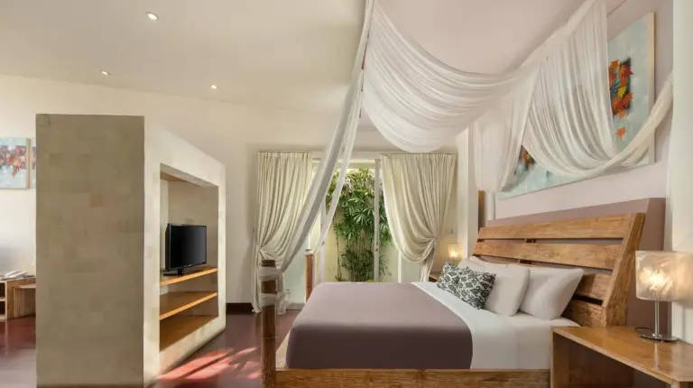 a bedroom with a large bed and a television at The Seiryu Boutique Bali Villas in Seminyak