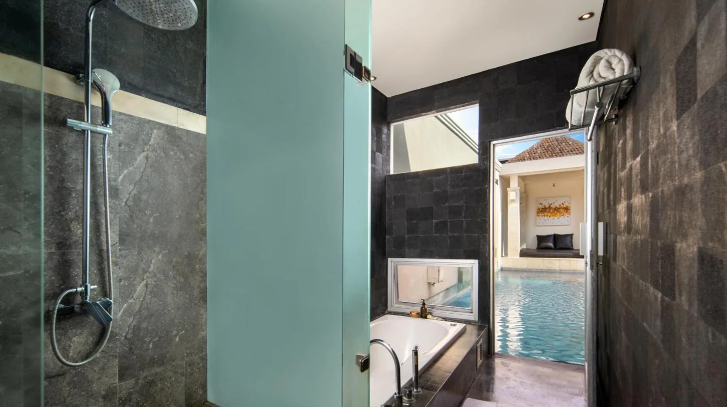 a bathroom with a tub and a glass shower at The Seiryu Boutique Bali Villas in Seminyak