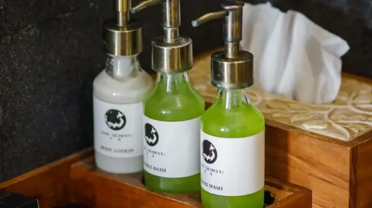 three bottles of soap in a wooden tray at The Seiryu Boutique Bali Villas in Seminyak