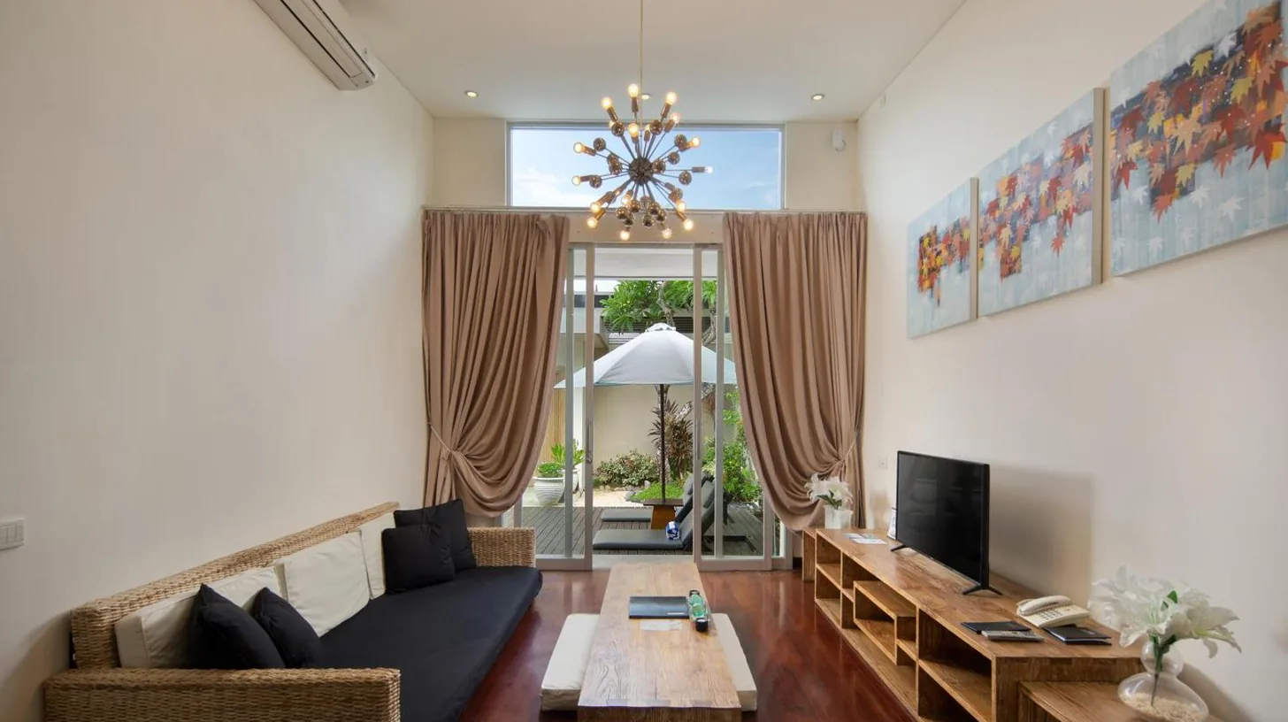 a dining room with a wooden table and chairs at The Seiryu Boutique Bali Villas in Seminyak