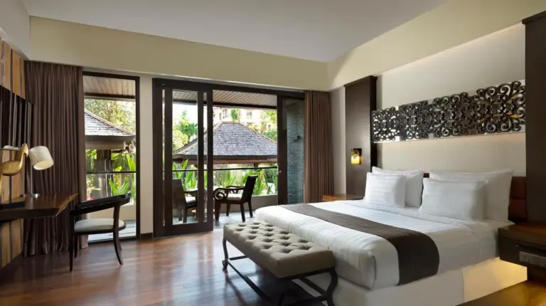 an outdoor patio with chairs and a pool at The Seminyak Beach Resort & Spa in Seminyak