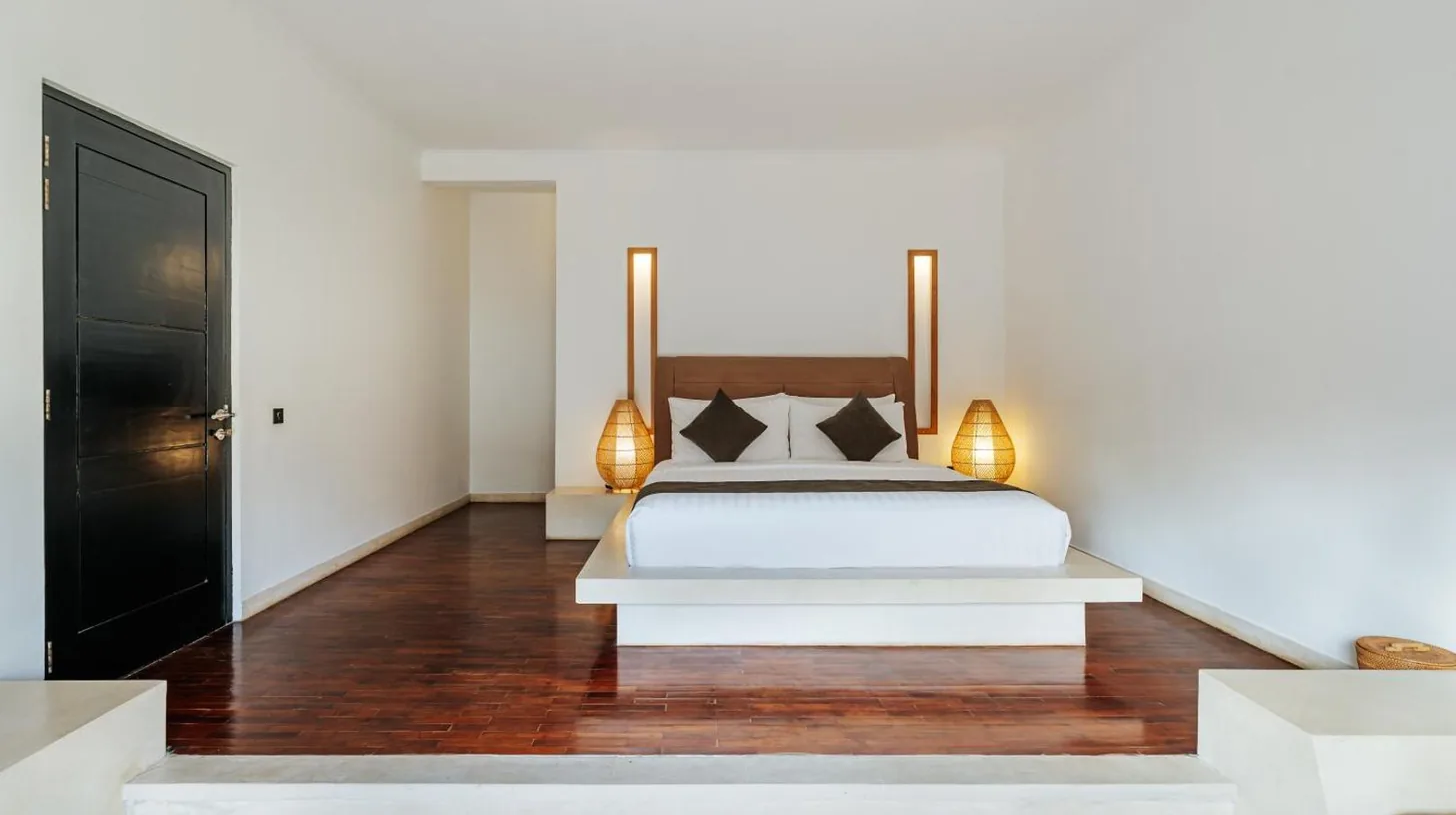 a bedroom with a white bed and two lamps at The Seminyak Suites Private Villas in Seminyak