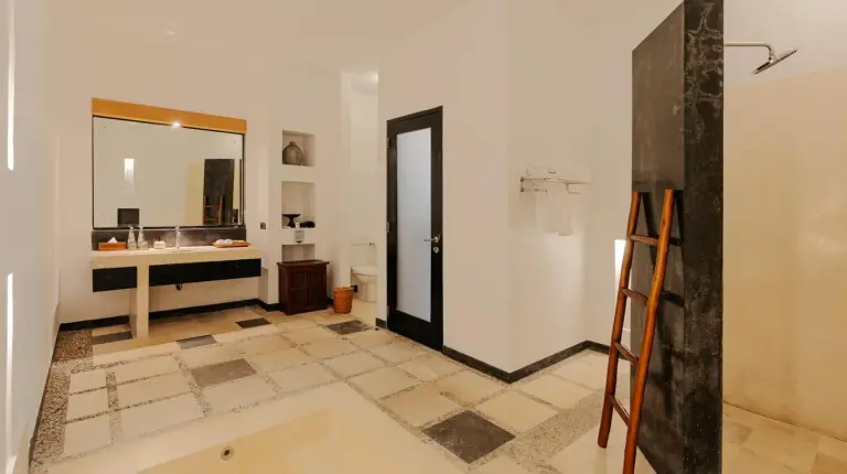 a bathroom with a ladder and a sink and a mirror at The Seminyak Suites Private Villas in Seminyak