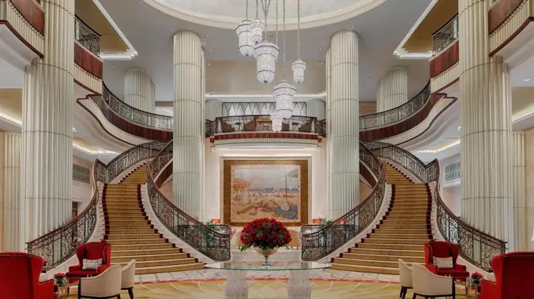 a large lobby with stairs and a vase of flowers at The St. Regis Abu Dhabi in Abu Dhabi