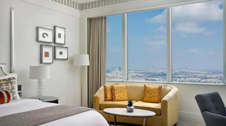 a bedroom with a bed and a couch and a large window at The St. Regis Abu Dhabi in Abu Dhabi