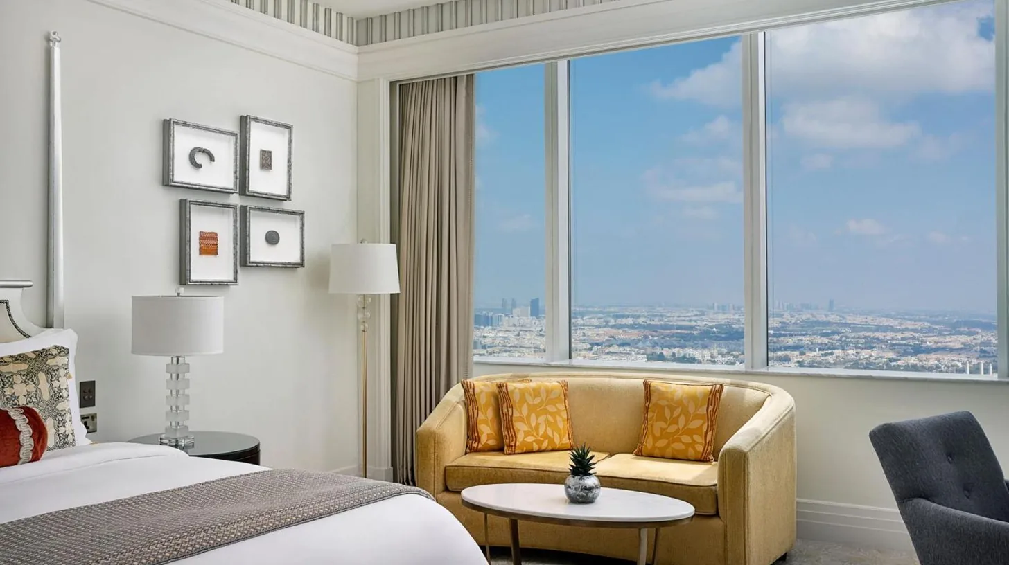 a bedroom with a bed and a couch and a large window at The St. Regis Abu Dhabi in Abu Dhabi